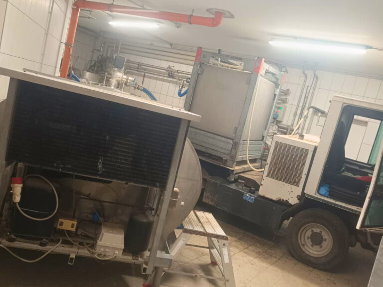 Milchraum mit Milchtank und Boki-Transportfahrzeug in einem landwirtschaftlichen Betrieb